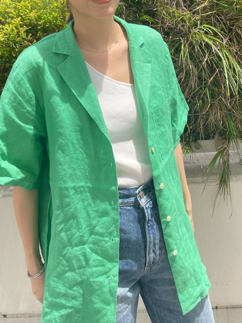 ホワイト系のタンクトップ、ブラック系のサンダル、グリーン系のシャツ/ブラウスを着用したレディースの春コーディネートの3枚目の写真