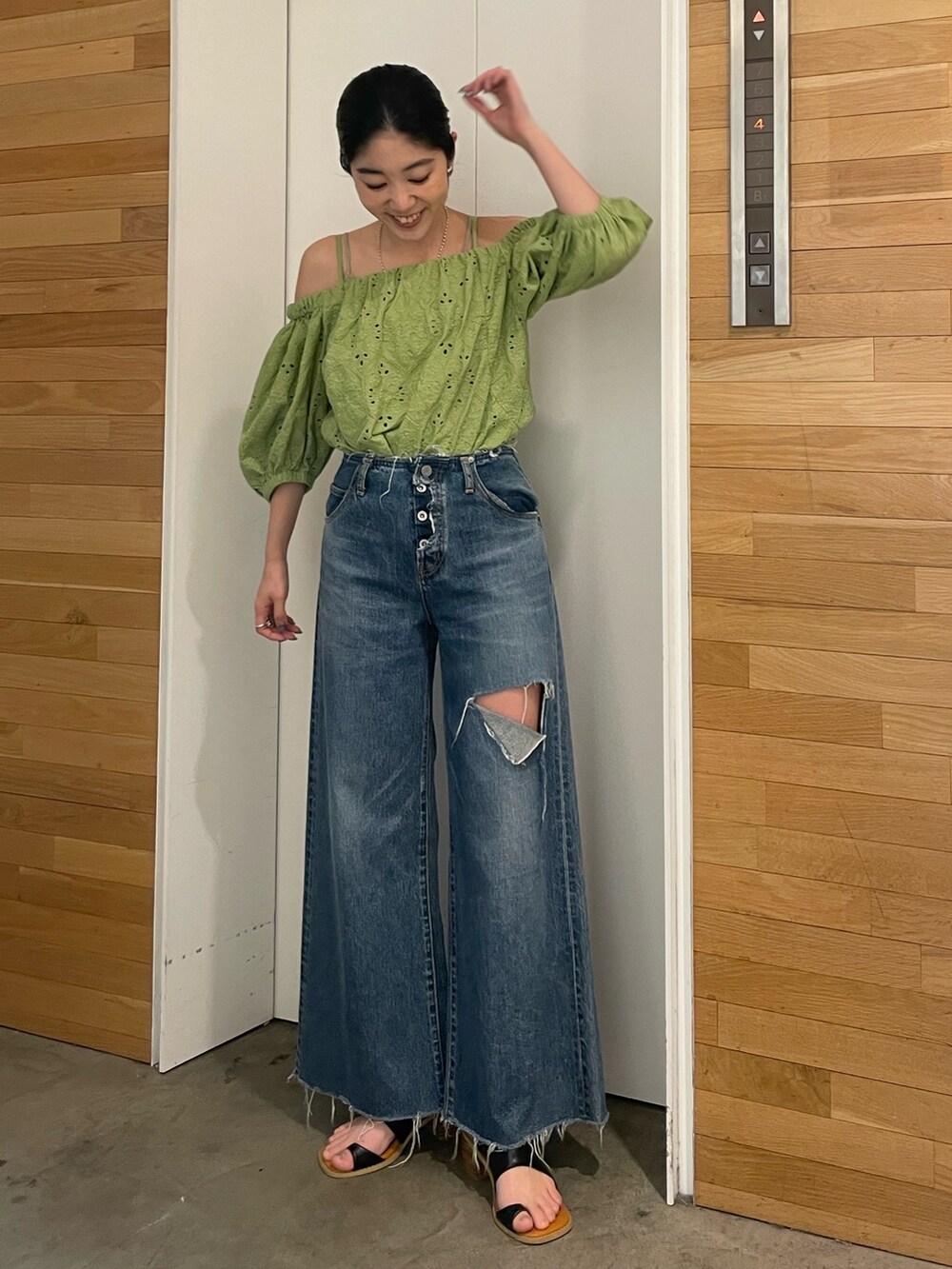 ブルー系のデニムパンツ、ブラック系のサンダル、グリーン系のシャツ/ブラウスを着用したレディースの春コーディネートの4枚目の写真