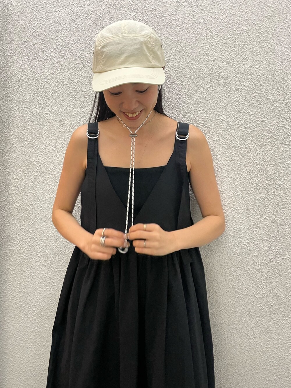 ブラック系のワンピース、ホワイト系のキャップを着用したレディースの春コーディネートの4枚目の写真