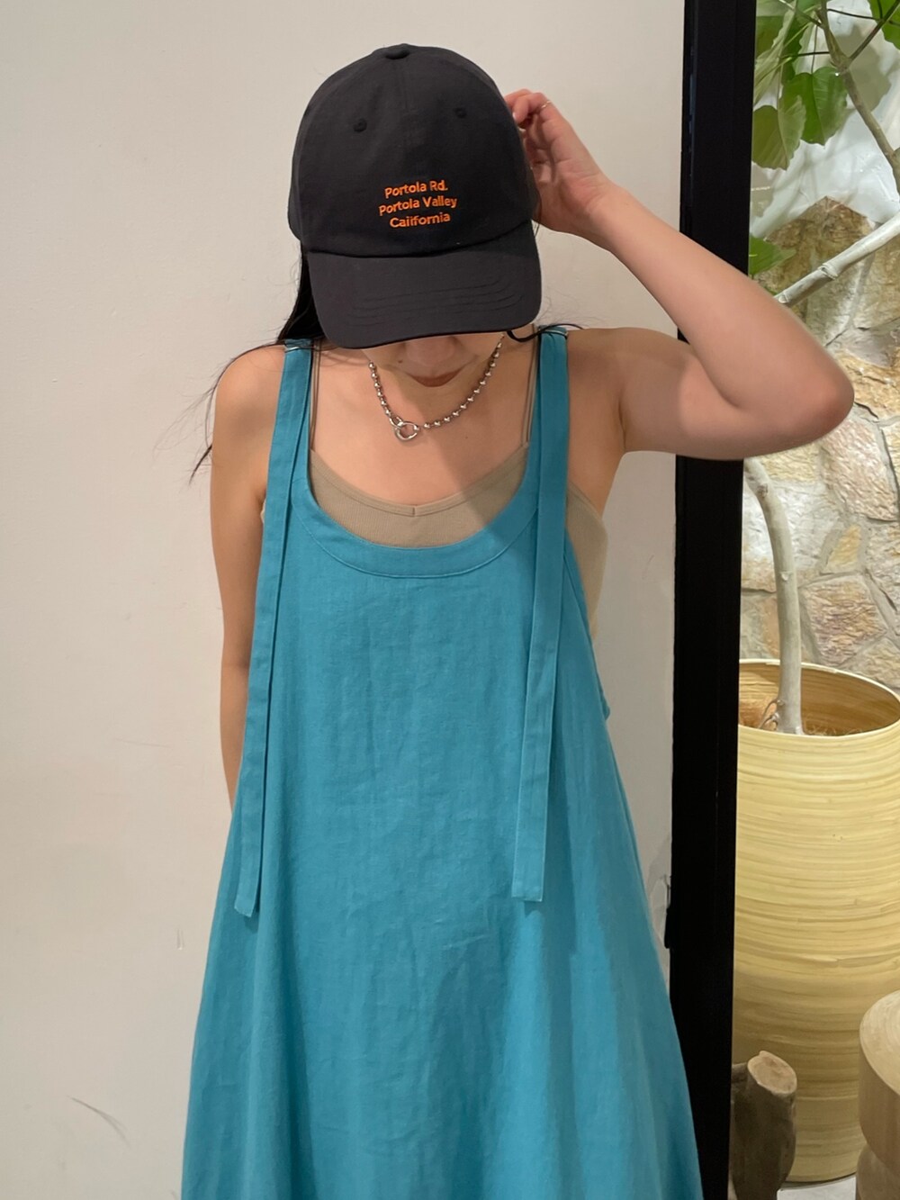 ブルー系のワンピース、グレー系のキャミソール、グレー系のキャップを着用したレディースの夏コーディネートの5枚目の写真