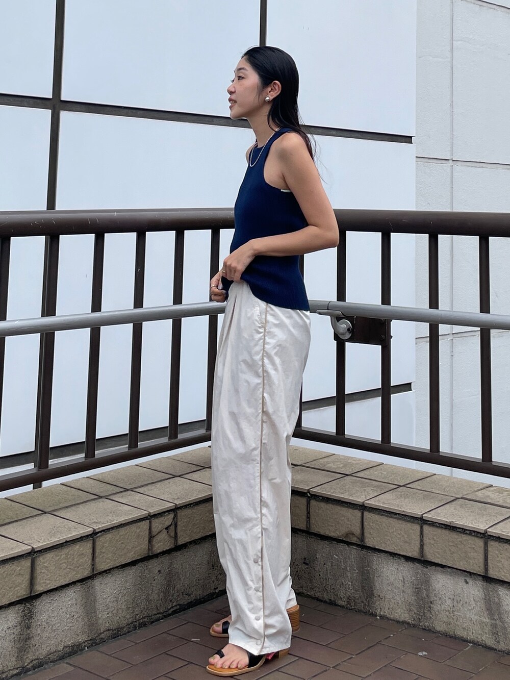ブラック系のサンダル、ブルー系のタンクトップ、ホワイト系のその他パンツを着用したレディースの夏コーディネートの3枚目の写真