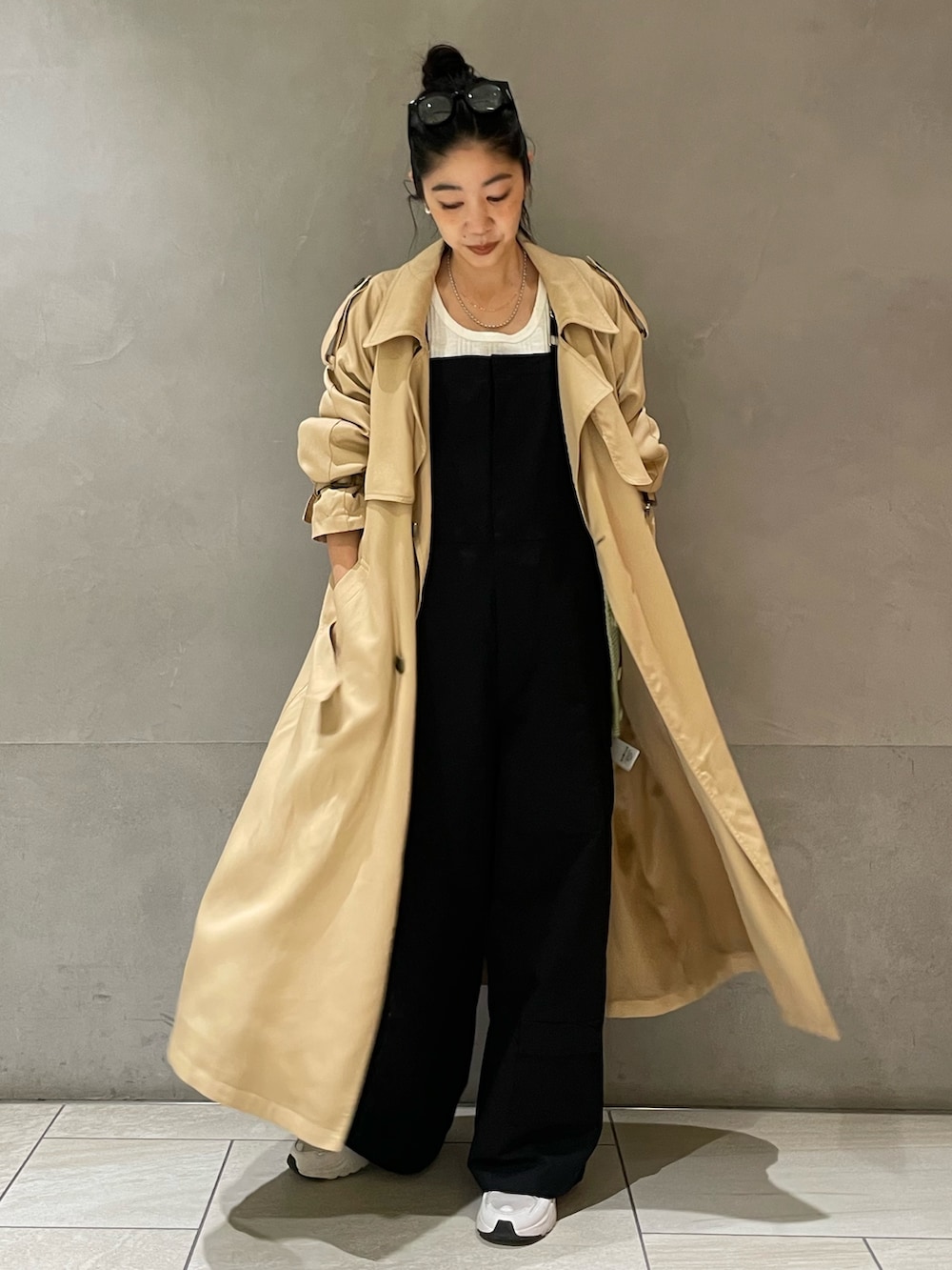 ベージュ系のトレンチコートを着用したレディースの春コーディネートの2枚目の写真