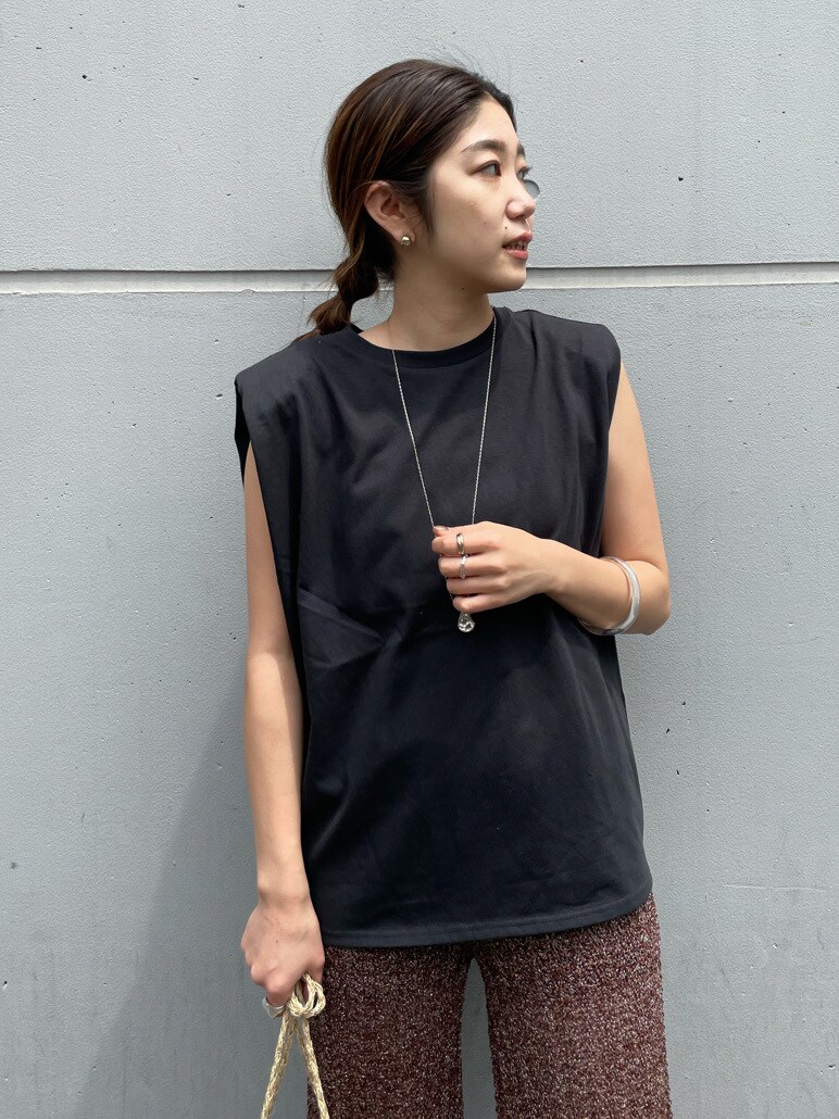 ベージュ系のかごバッグ、ブラウン系のその他パンツを着用したレディースの春コーディネートの2枚目の写真