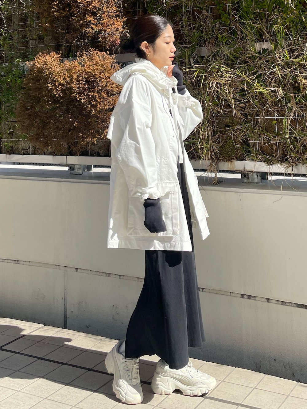 ブラック系のワンピースを着用したレディースの春コーディネートの2枚目の写真