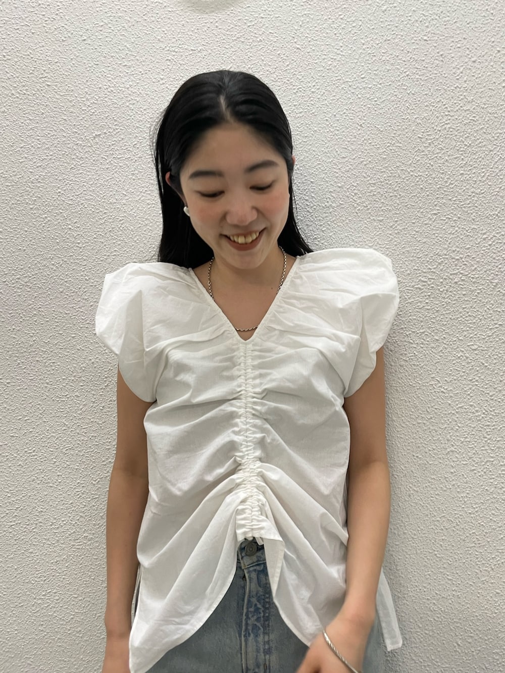 ホワイト系のシャツ/ブラウス、ブルー系のデニムパンツ、シルバー系のサンダルを着用したレディースの春コーディネートの6枚目の写真