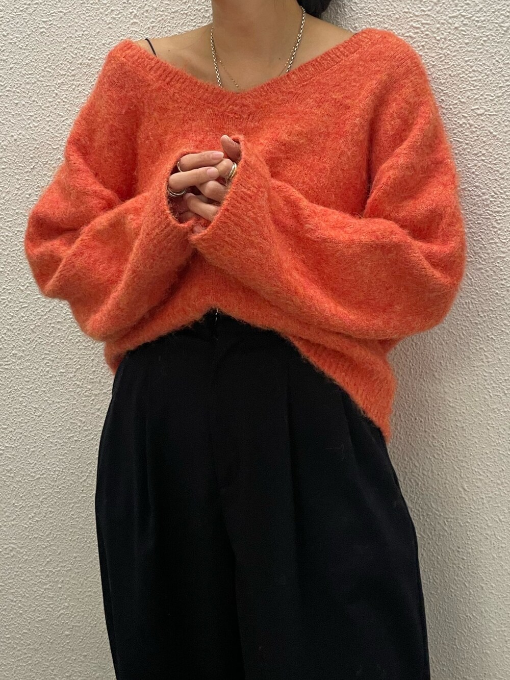 オレンジ系のニット/セーターを着用したレディースの冬コーディネートの5枚目の写真