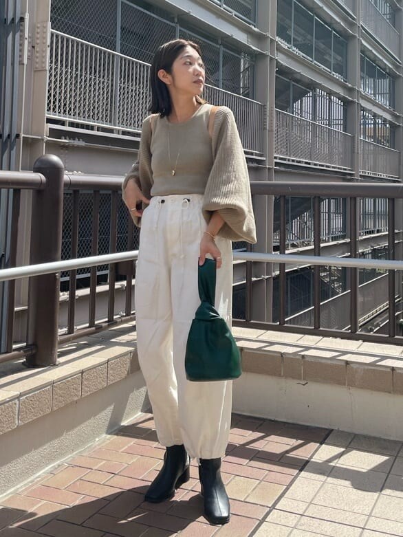 ホワイト系のその他パンツ、ブラック系のブーツ、ベージュ系のカーディガン/ボレロを着用したレディースの秋コーディネートの2枚目の写真