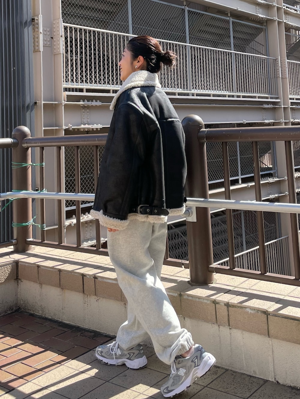 グレー系のスウェットパンツ、ブラック系のニット/セーター、ブラック系のムートンコートを着用したレディースの秋コーディネートの6枚目の写真