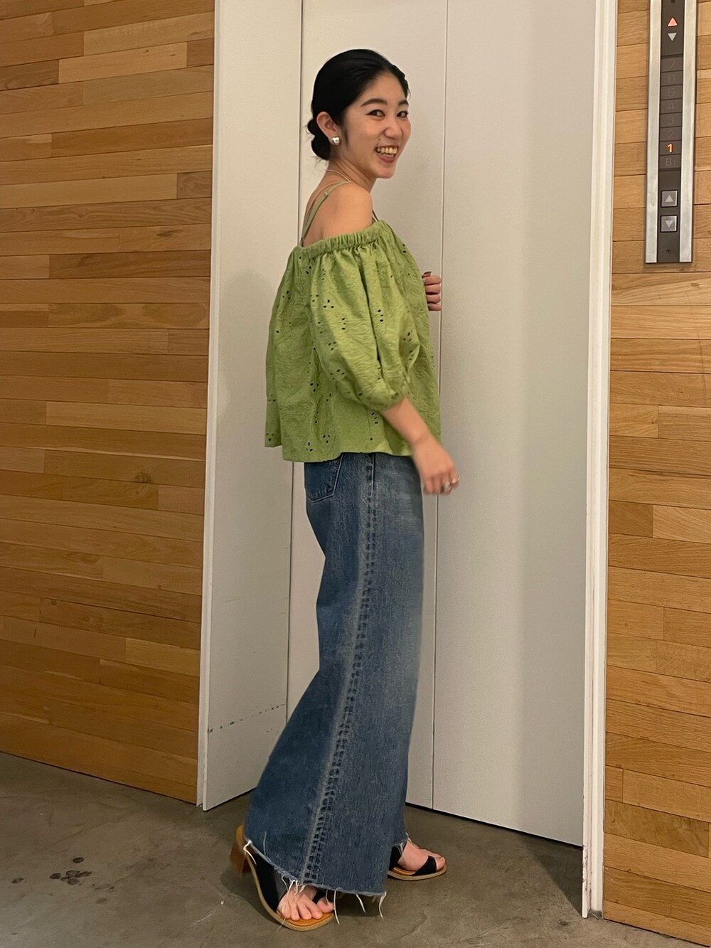 ブルー系のデニムパンツ、ブラック系のサンダル、グリーン系のシャツ/ブラウスを着用したレディースの春コーディネートの2枚目の写真