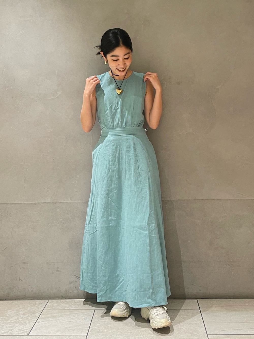 ブルー系のワンピース、ゴールド系のネックレスを着用したレディースの春コーディネートの5枚目の写真