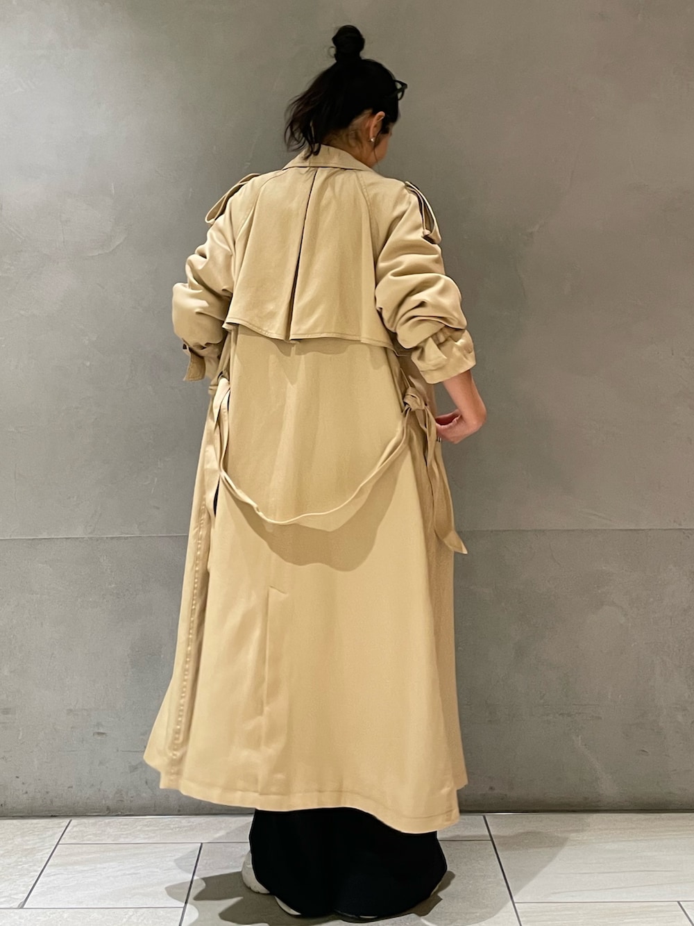 ベージュ系のトレンチコートを着用したレディースの春コーディネートの6枚目の写真