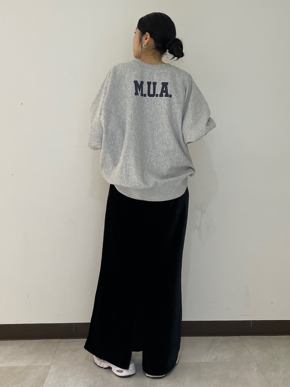 グレー系のスウェット、ブラック系のスカートを着用したレディースの秋コーディネートの3枚目の写真