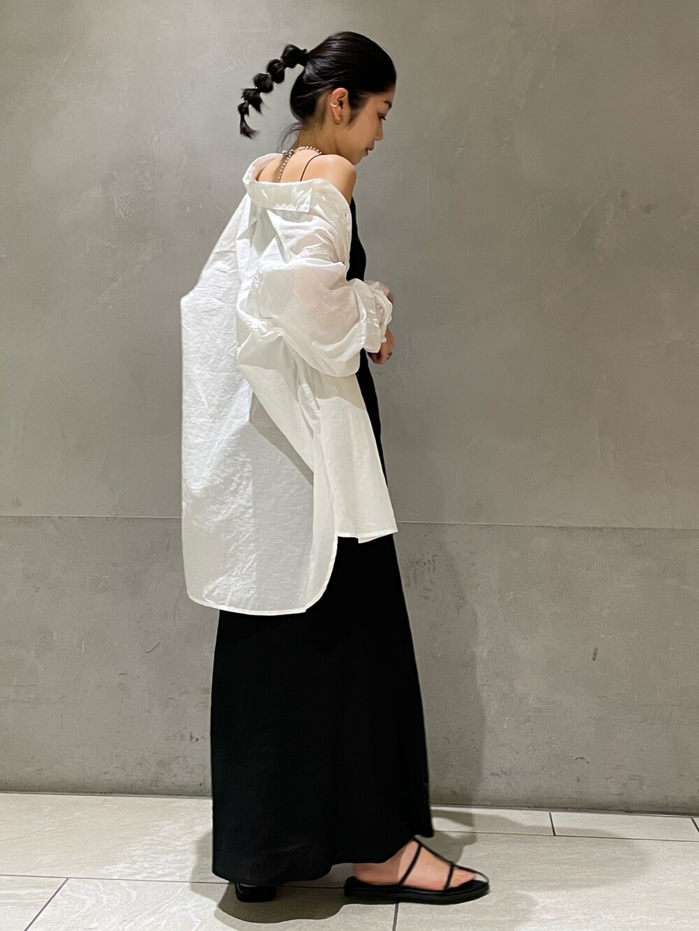 ブラック系のスカート、ホワイト系のシャツ/ブラウス、ブラック系のサンダルを着用したレディースの春コーディネートの2枚目の写真