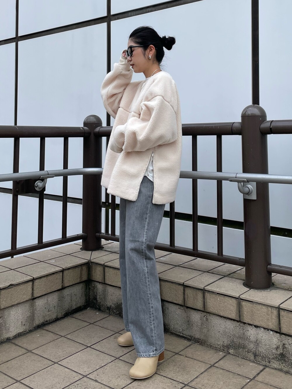 ホワイト系のTシャツ/カットソー、ブラック系のデニムパンツ、ベージュ系のブーツを着用したレディースの秋コーディネートの3枚目の写真