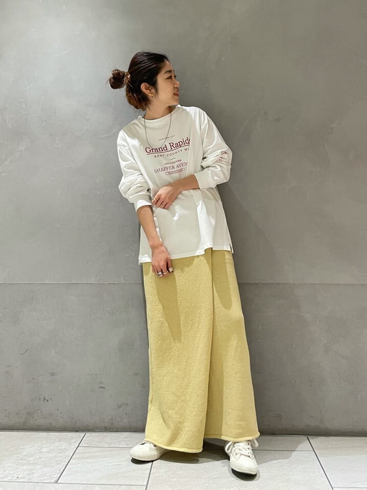 イエロー系のスカート、ホワイト系のTシャツ/カットソーを着用したレディースの冬コーディネートの2枚目の写真
