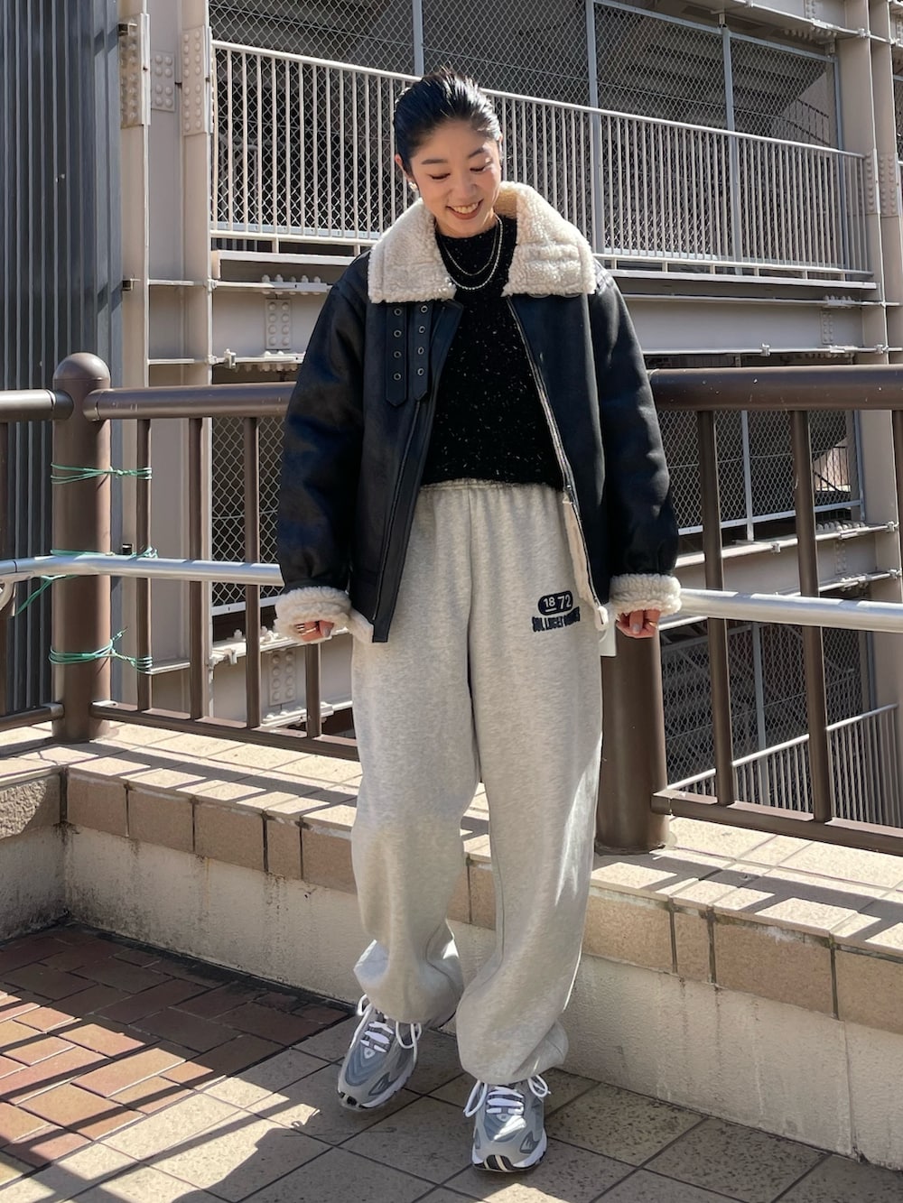 グレー系のスウェットパンツ、ブラック系のニット/セーター、ブラック系のムートンコートを着用したレディースの秋コーディネートの7枚目の写真