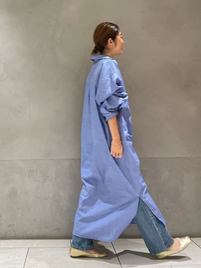 ブルー系のデニムパンツ、ブルー系のワンピース、ブラック系のキャミソールを着用したレディースの夏コーディネートの5枚目の写真