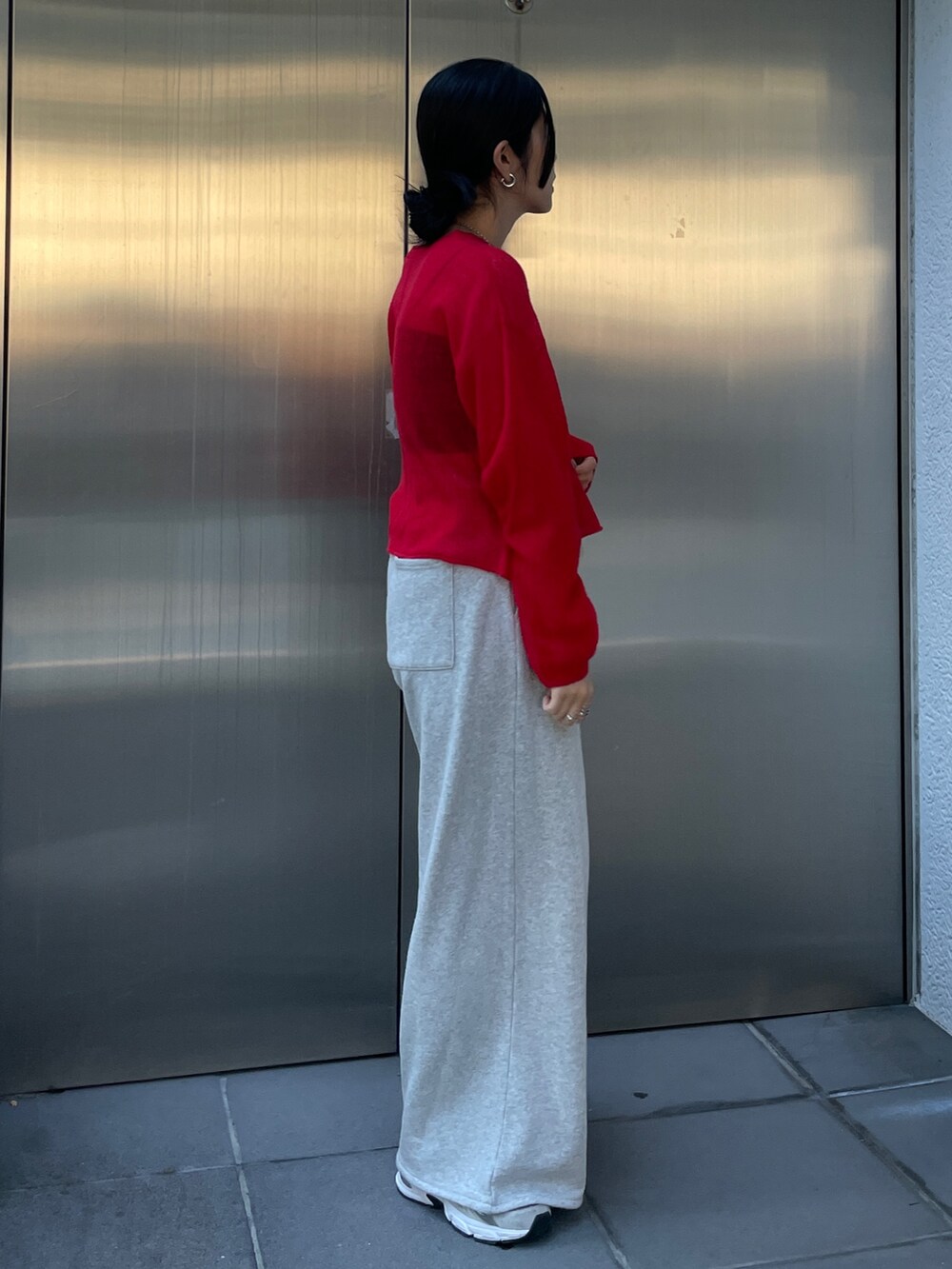 グレー系のスウェットパンツ、レッド系のニット/セーターを着用したレディースの秋コーディネートの4枚目の写真