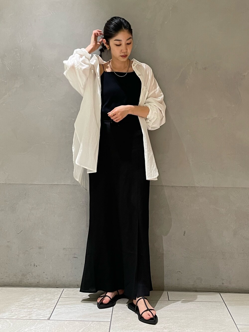 ブラック系のスカート、ホワイト系のシャツ/ブラウス、ブラック系のサンダルを着用したレディースの春コーディネートの3枚目の写真