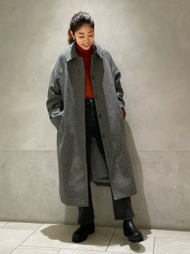 グレー系のステンカラーコート、オレンジ系のニット/セーターを着用したレディースの秋コーディネートの3枚目の写真