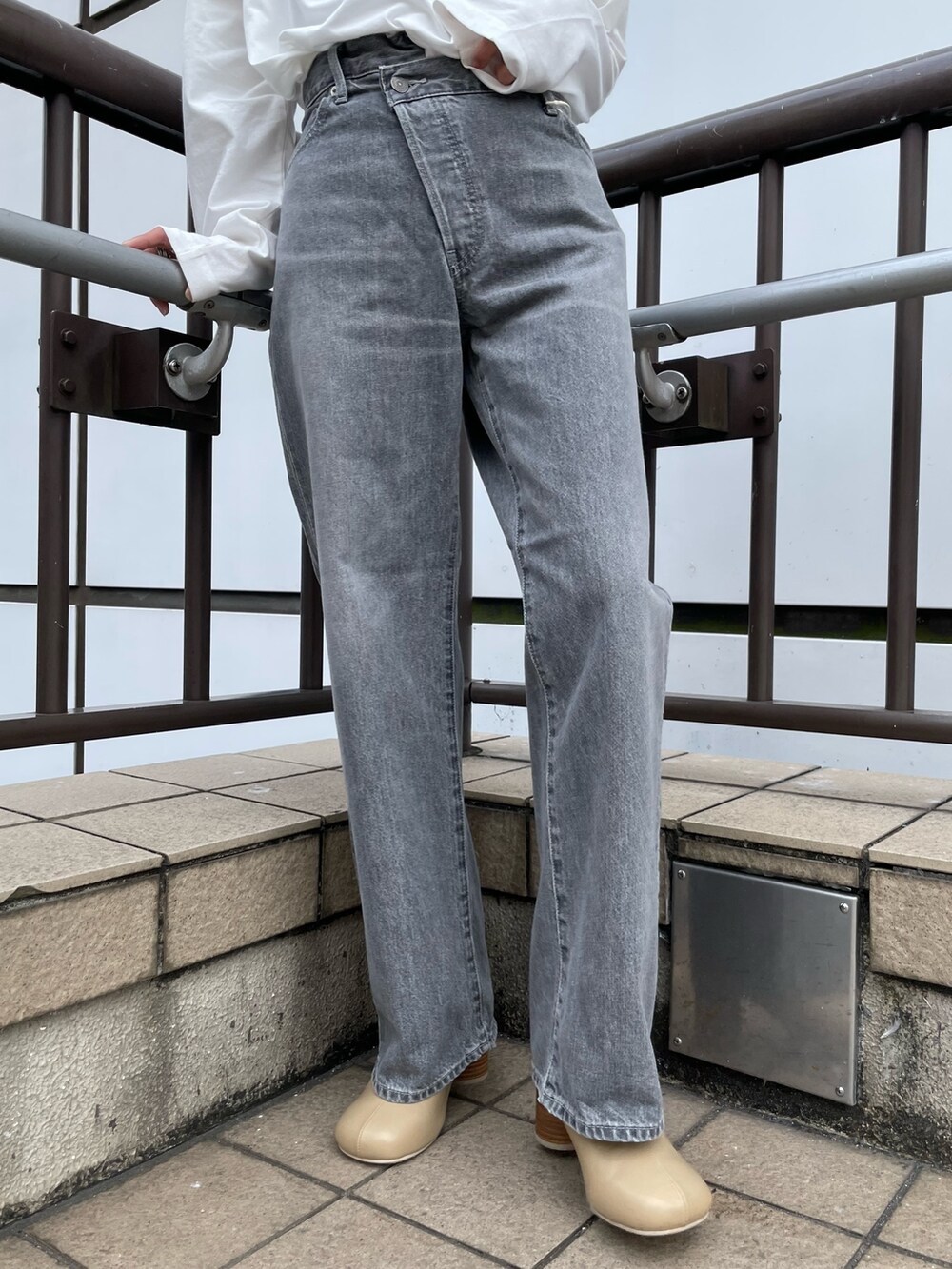 ホワイト系のTシャツ/カットソー、ブラック系のデニムパンツ、ベージュ系のブーツを着用したレディースの秋コーディネートの6枚目の写真