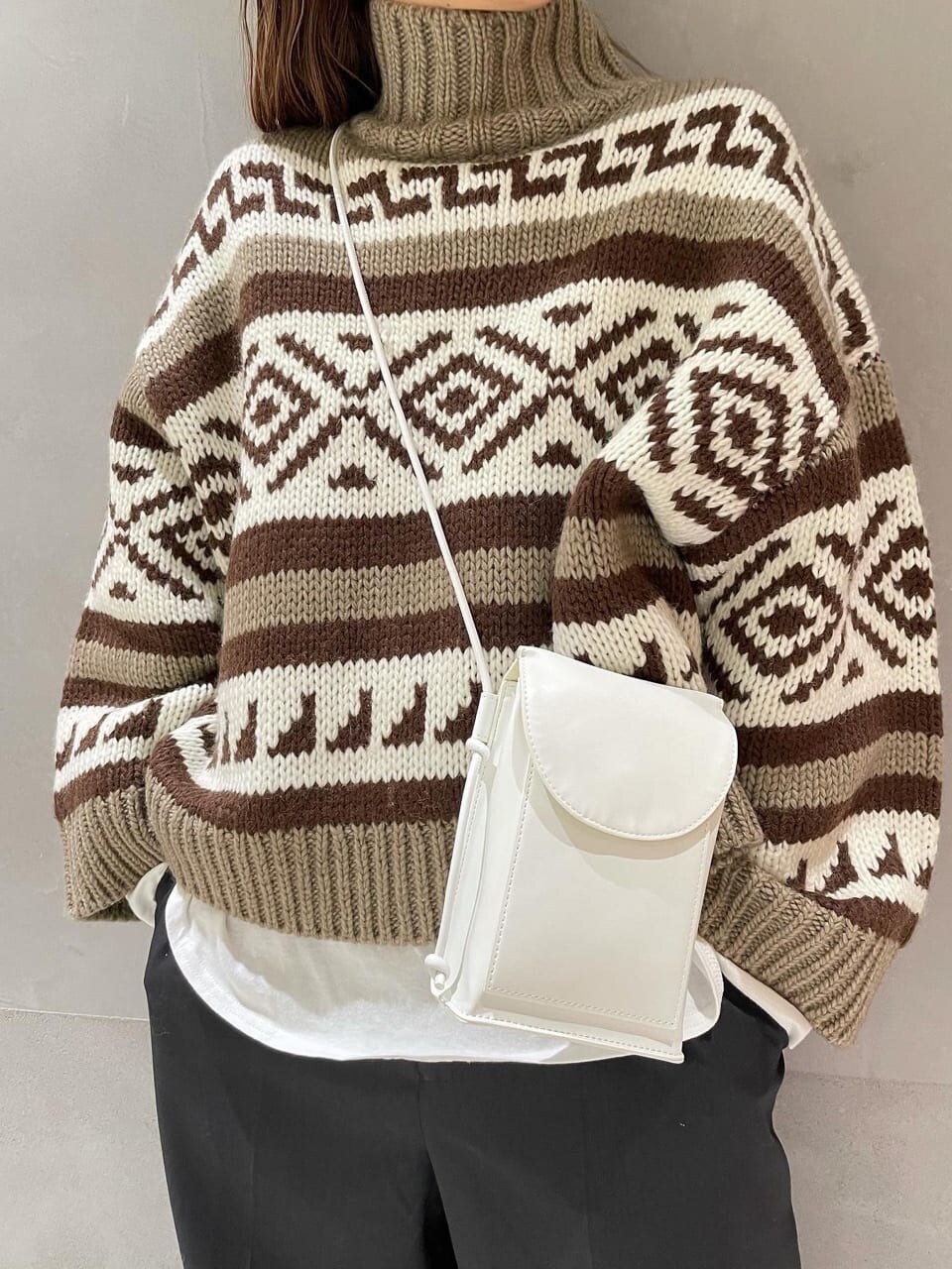 グレー系のその他パンツ、ベージュ系のニット/セーター、ホワイト系のTシャツ/カットソーを着用したレディースの冬コーディネートの2枚目の写真