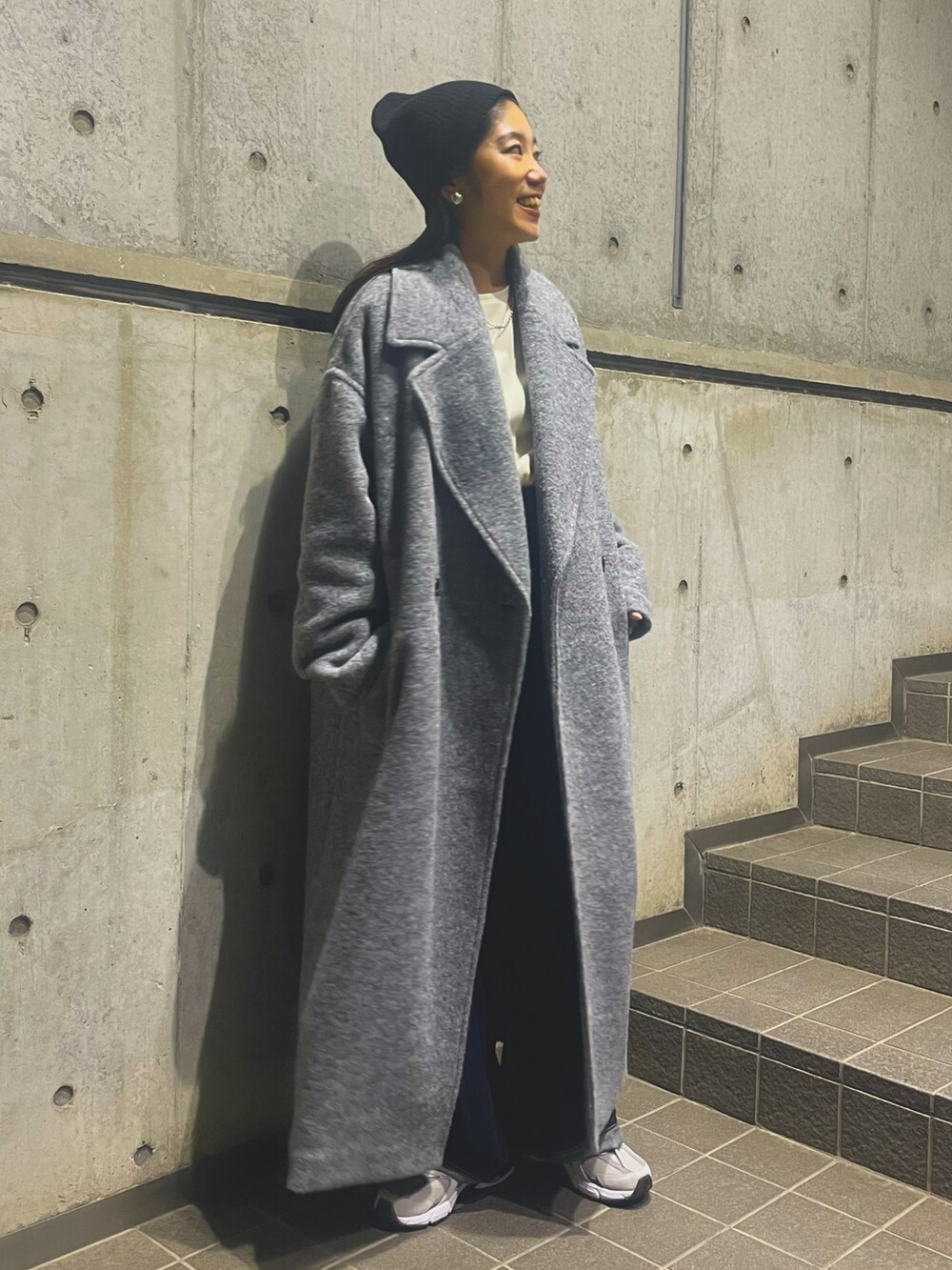 グレー系のチェスターコート、ブラック系のニットキャップ/ビーニーを着用したレディースの秋コーディネートの2枚目の写真