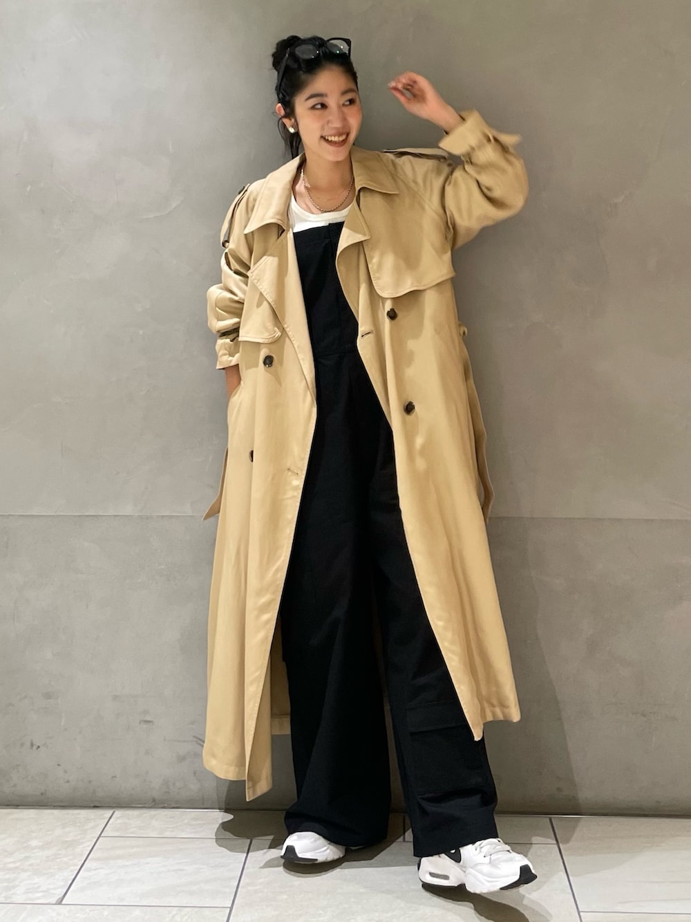ベージュ系のトレンチコートを着用したレディースの春コーディネートの5枚目の写真