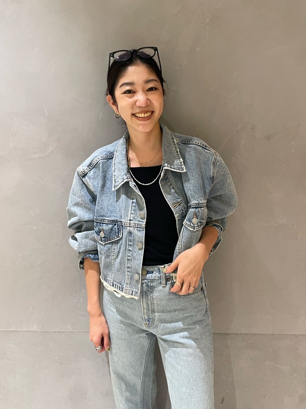 ブルー系のデニムジャケット、ブルー系のデニムパンツ、シルバー系のパンプスを着用したレディースの夏コーディネートの3枚目の写真
