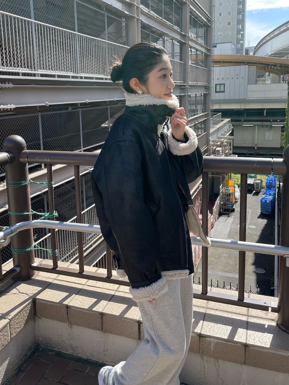 グレー系のスウェットパンツ、ブラック系のニット/セーター、ブラック系のムートンコートを着用したレディースの秋コーディネートの2枚目の写真