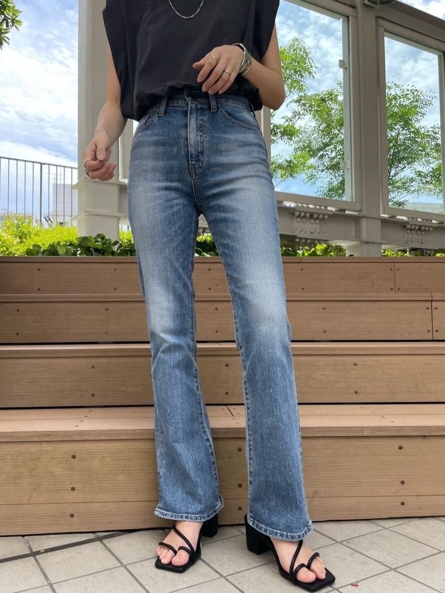 グレー系のタンクトップ、ブルー系のデニムパンツを着用したレディースの夏コーディネートの3枚目の写真