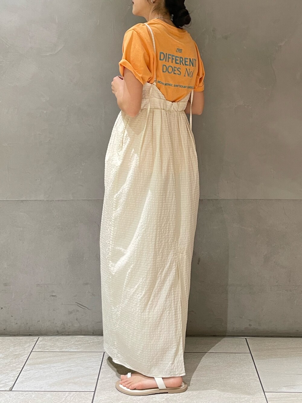 ホワイト系のワンピース、オレンジ系のTシャツ/カットソー、ホワイト系のサンダルを着用したレディースの夏コーディネートの3枚目の写真