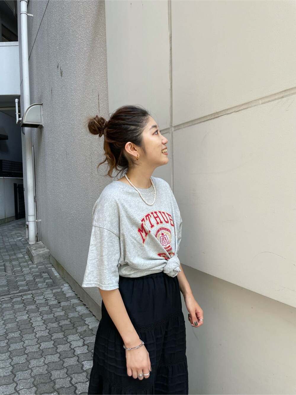 グレー系のTシャツ/カットソー、ホワイト系のスカートを着用したレディースの夏コーディネートの3枚目の写真