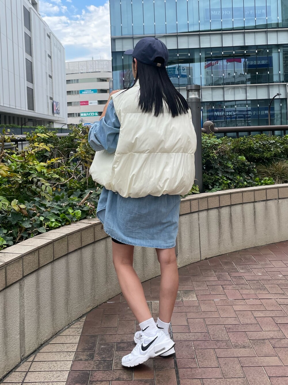 ブルー系のシャツ/ブラウス、ブラック系のショルダーバッグ、ホワイト系のダウンベストを着用したレディースの秋コーディネートの3枚目の写真