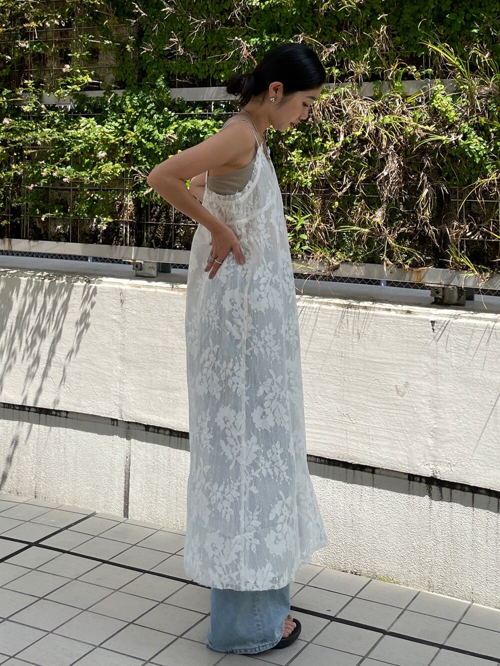 ホワイト系のワンピース、グレー系のキャミソール、ブルー系のデニムパンツを着用したレディースの夏コーディネートの3枚目の写真