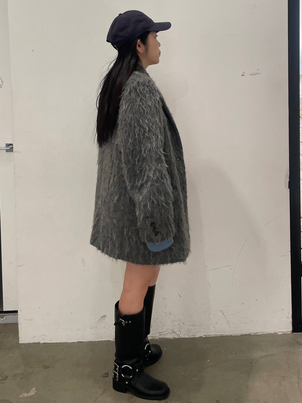 グレー系のテーラードジャケット、ブラック系のブーツ、グレー系のスカートを着用したレディースの秋コーディネートの4枚目の写真