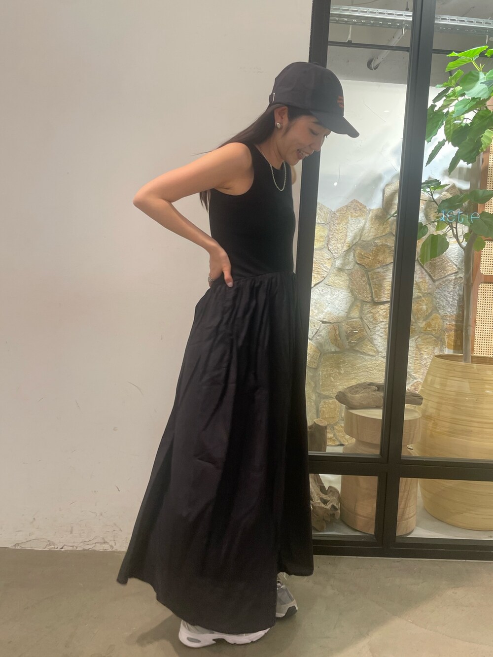 ブラック系のワンピース、グレー系のキャップを着用したレディースの春コーディネートの4枚目の写真