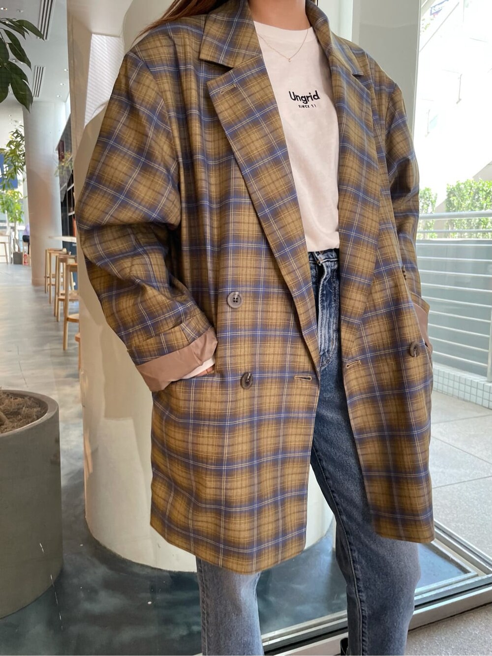 イエロー系のテーラードジャケット、ブルー系のデニムパンツ、ホワイト系のTシャツ/カットソーを着用したレディースの夏コーディネートの4枚目の写真