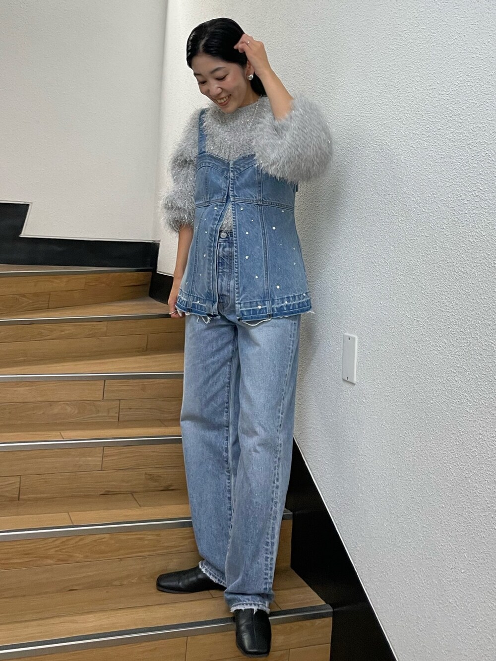 シルバー系のニット/セーター、ブルー系のタンクトップ、ブルー系のデニムパンツを着用したレディースの秋コーディネートの2枚目の写真