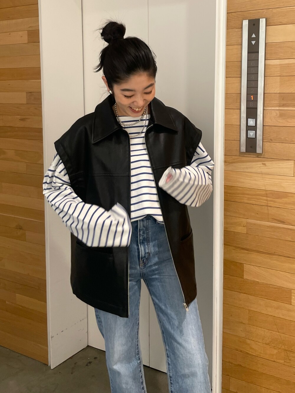 ブルー系のデニムパンツ、ブラック系のブルゾンを着用したレディースの冬コーディネートの3枚目の写真