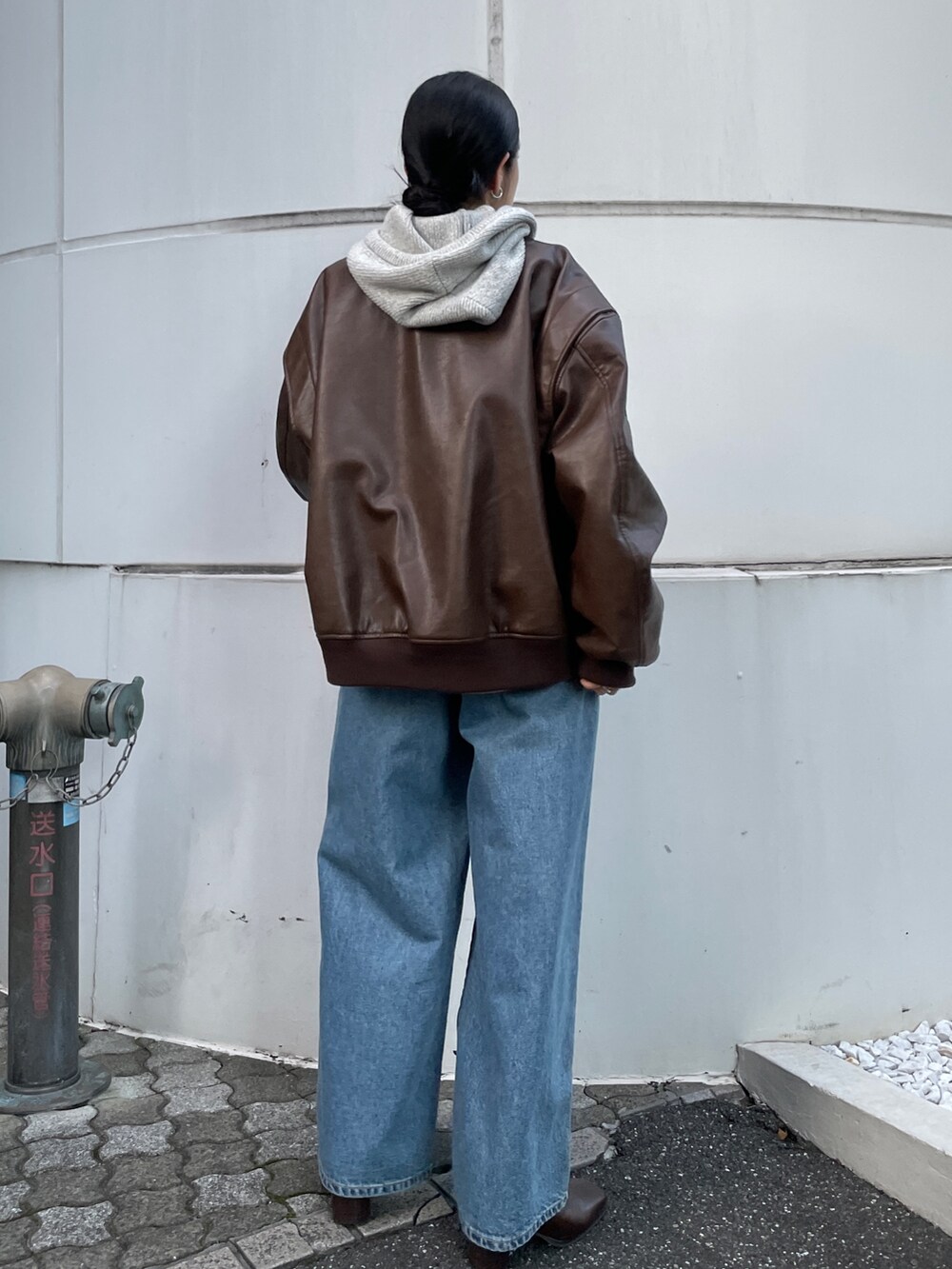 ブルー系のデニムパンツ、ブラウン系のブルゾン、ブラウン系のブーツを着用したレディースの秋コーディネートの4枚目の写真