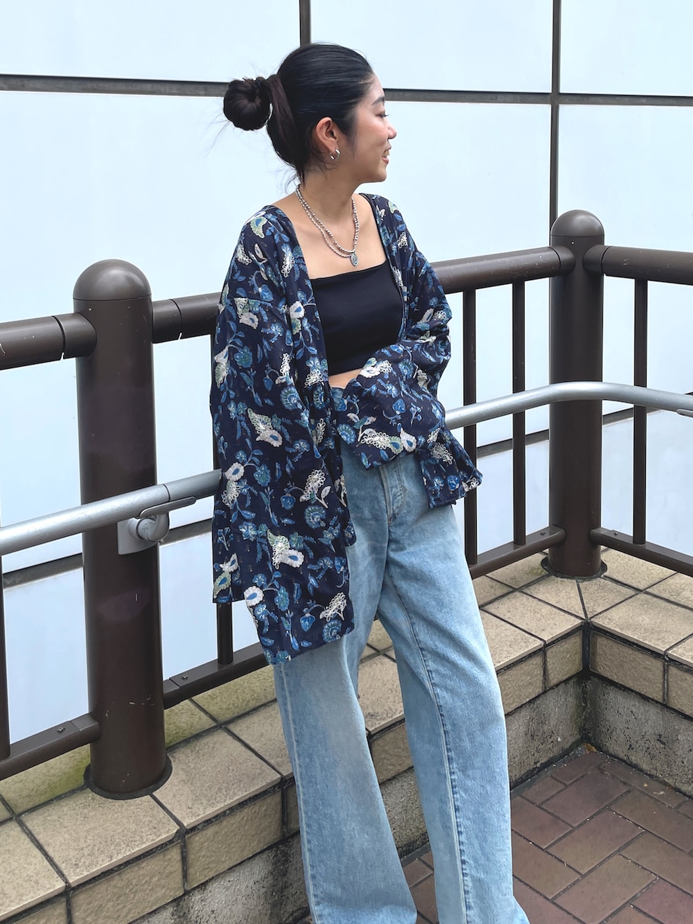 ブルー系のデニムパンツ、ゴールド系のローファー、ブルー系のシャツ/ブラウスを着用したレディースの夏コーディネートの5枚目の写真