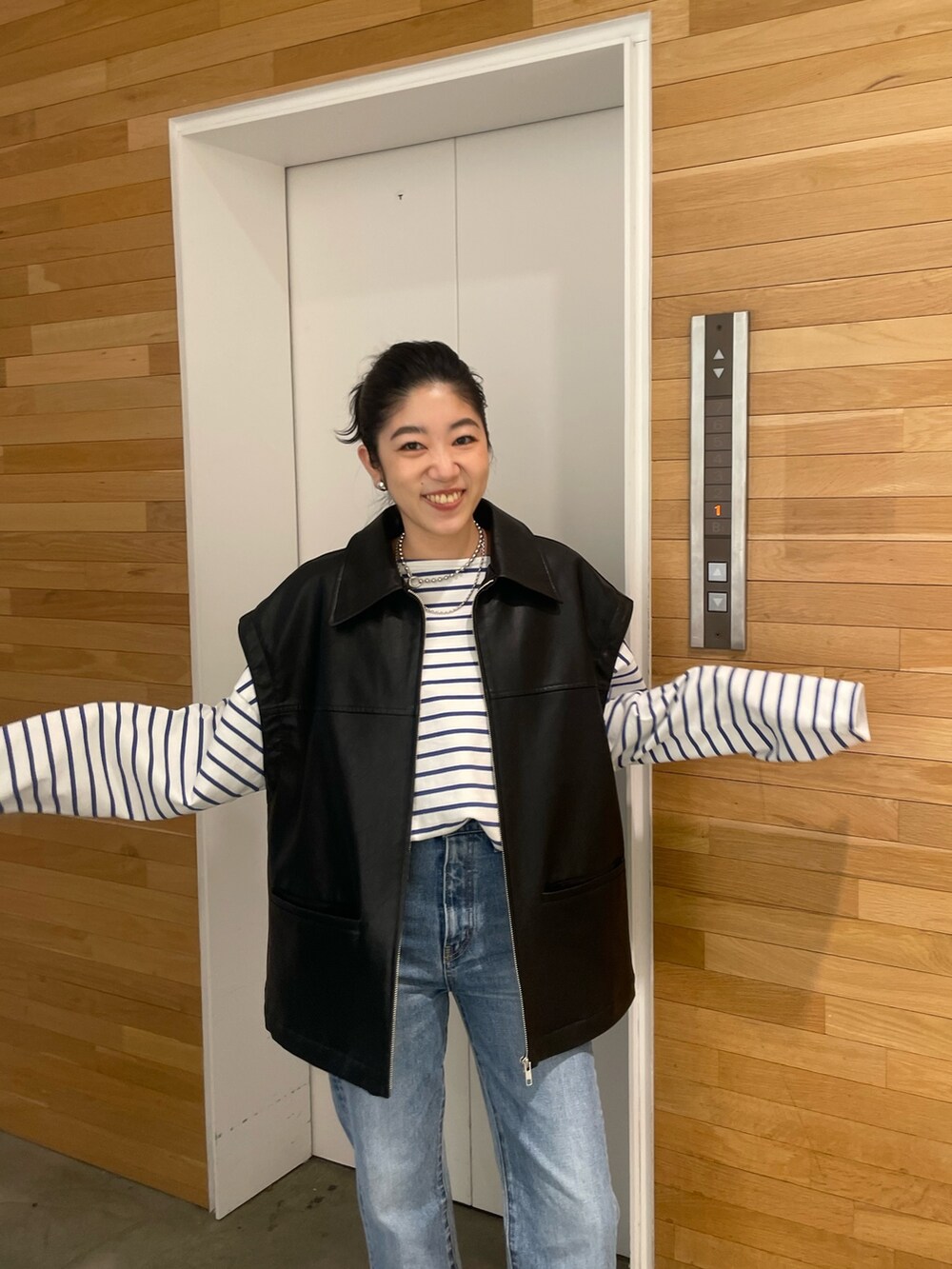 ブルー系のデニムパンツ、ブラック系のブルゾンを着用したレディースの冬コーディネートの2枚目の写真