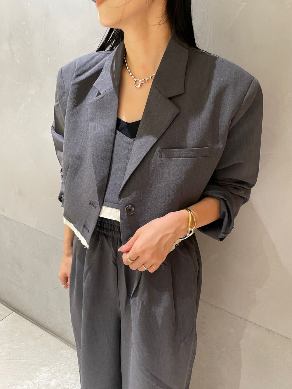 グレー系のその他パンツ、グレー系のテーラードジャケット、グレー系のキャミソールを着用したレディースの夏コーディネートの6枚目の写真