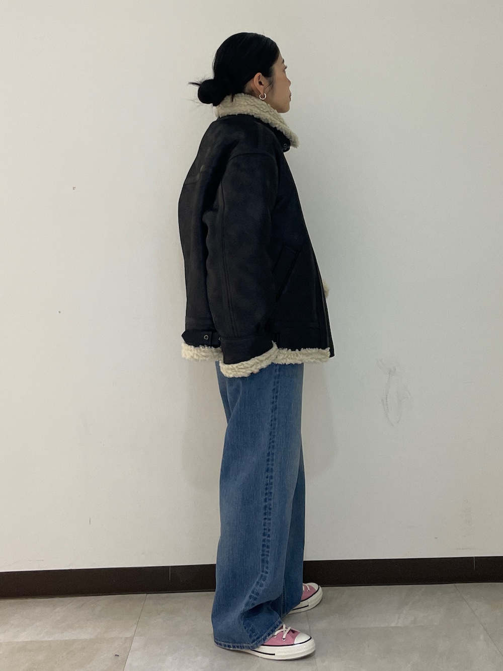 グレー系のニット/セーター、ブルー系のデニムパンツ、ブラック系のブルゾンを着用したレディースの秋コーディネートの8枚目の写真