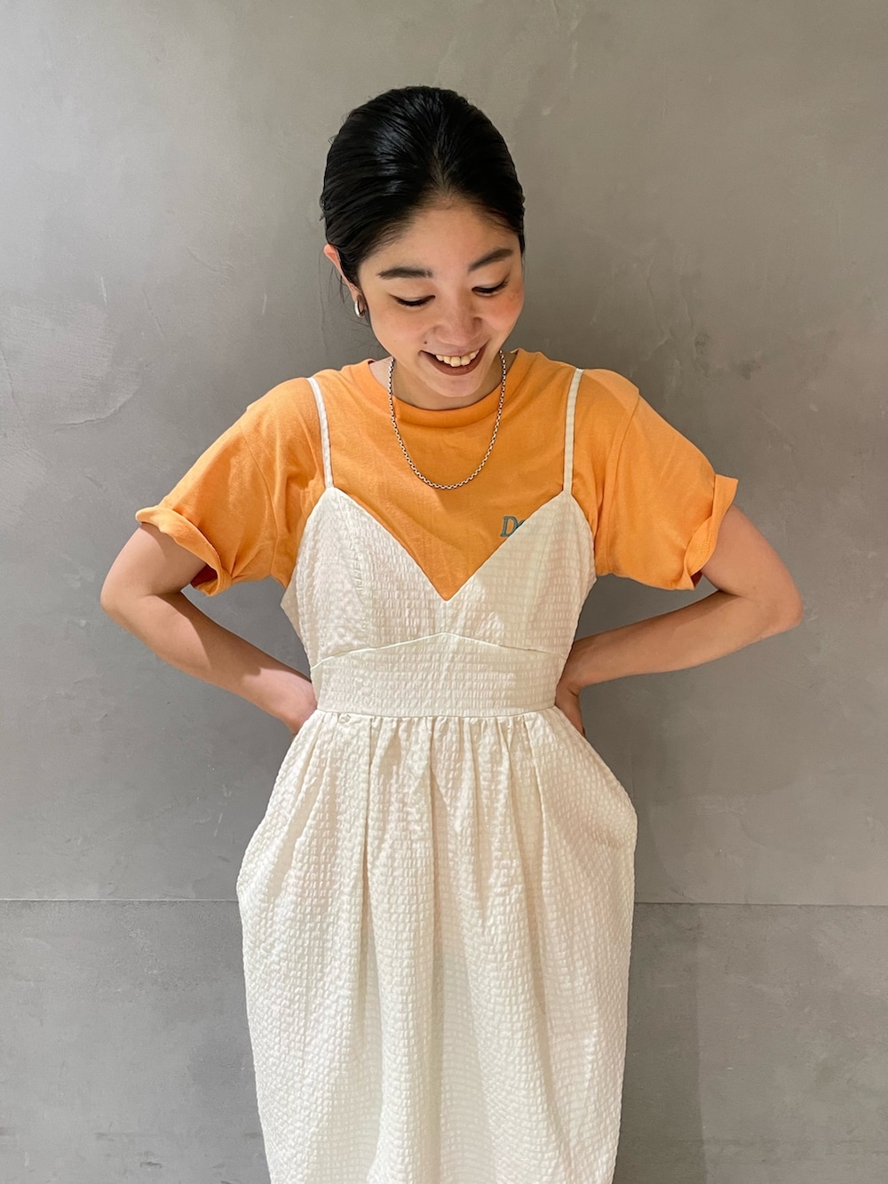 ホワイト系のワンピース、オレンジ系のTシャツ/カットソー、ホワイト系のサンダルを着用したレディースの夏コーディネートの6枚目の写真