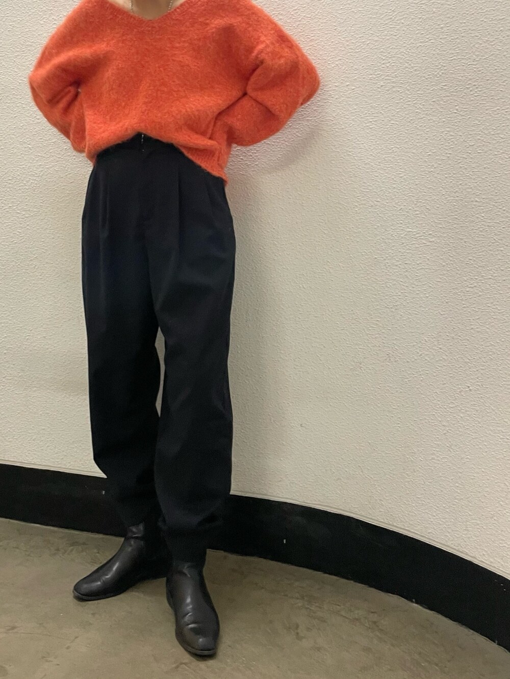 オレンジ系のニット/セーターを着用したレディースの冬コーディネートの3枚目の写真