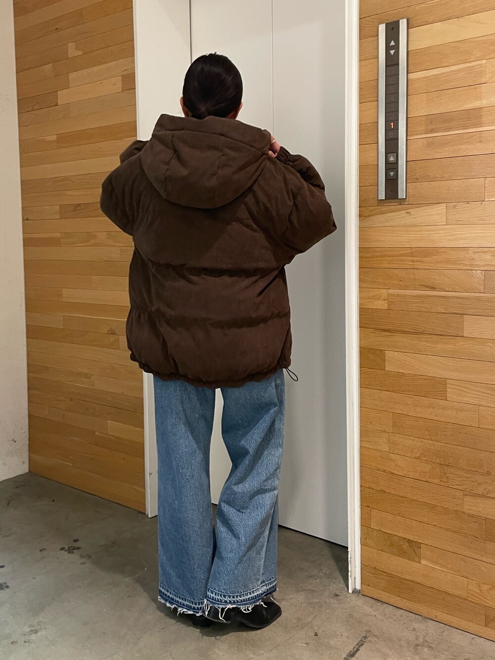 ブラウン系のブルゾン、ブルー系のデニムパンツを着用したレディースの冬コーディネートの3枚目の写真