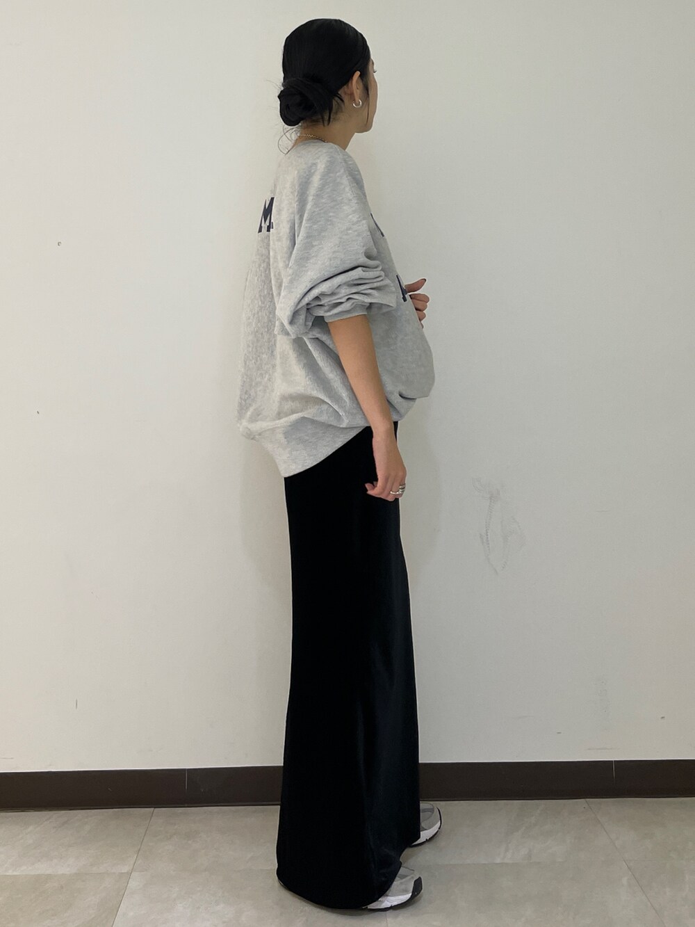 グレー系のスウェット、ブラック系のスカートを着用したレディースの秋コーディネートの2枚目の写真