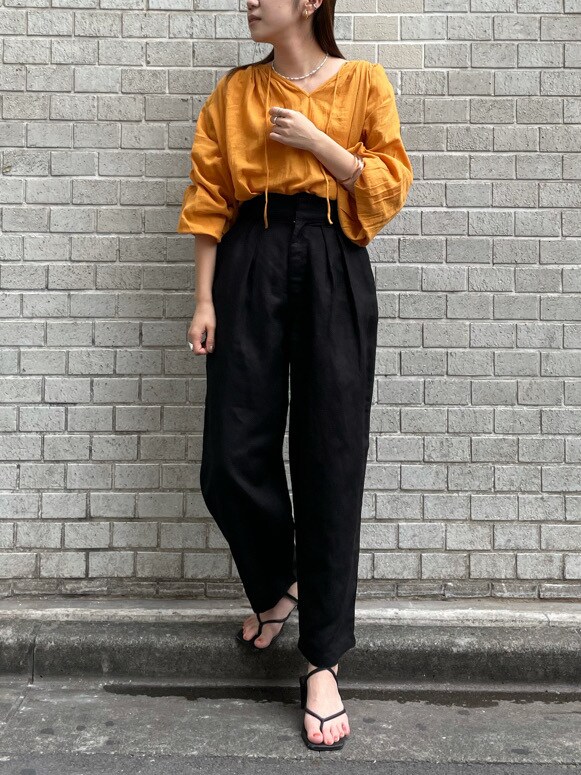 オレンジ系のシャツ/ブラウス、ブラック系のその他パンツを着用したレディースの夏コーディネートの3枚目の写真